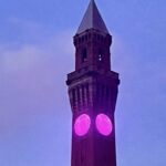 The clock at Birmingham University with purple lighting.